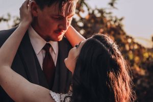 A tender embrace between newlyweds captured in warm evening light.