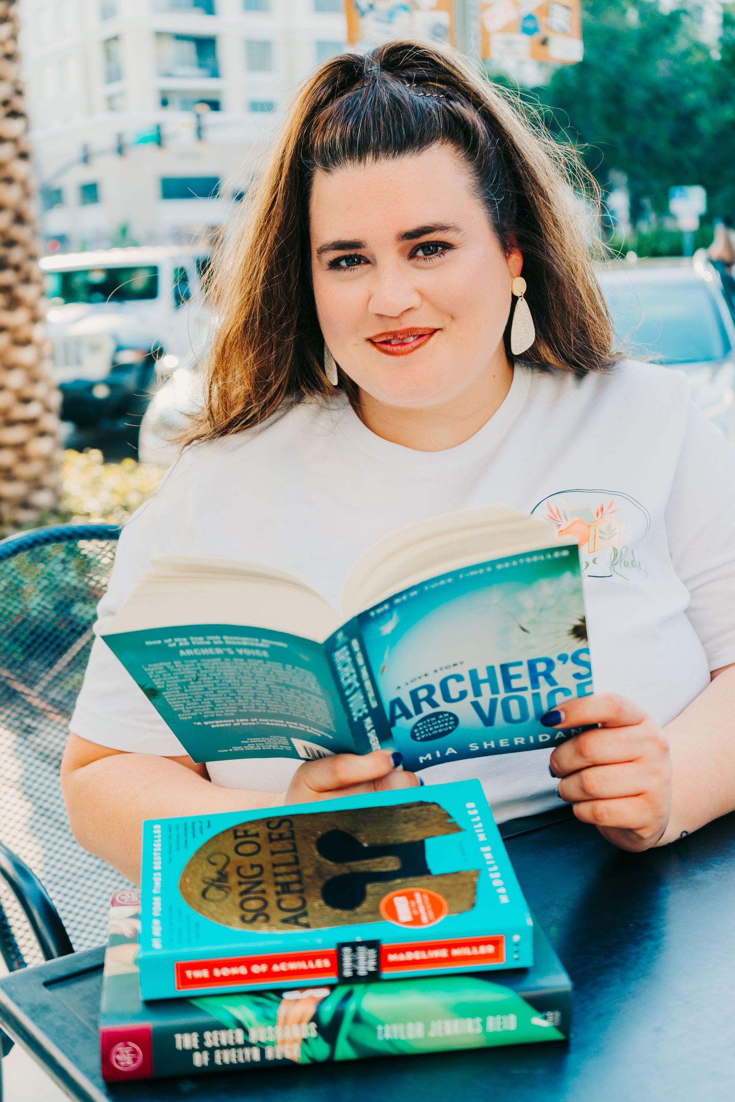 Outdoor Headshot Session in St. Pete, FL; Woman posing with books