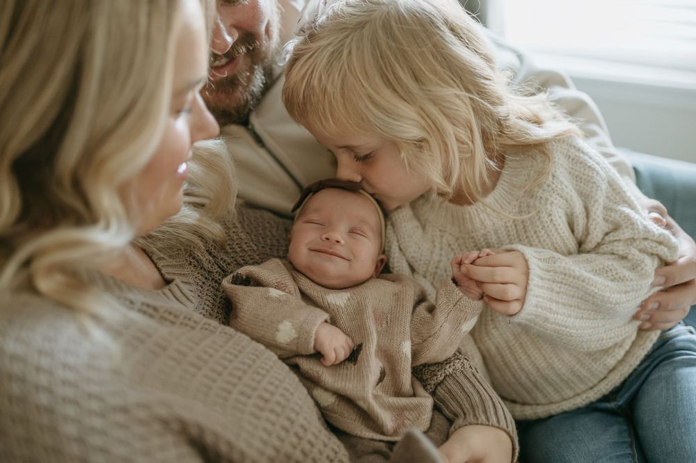 A sweet family moment shared on a comfortable bed with a newborn.