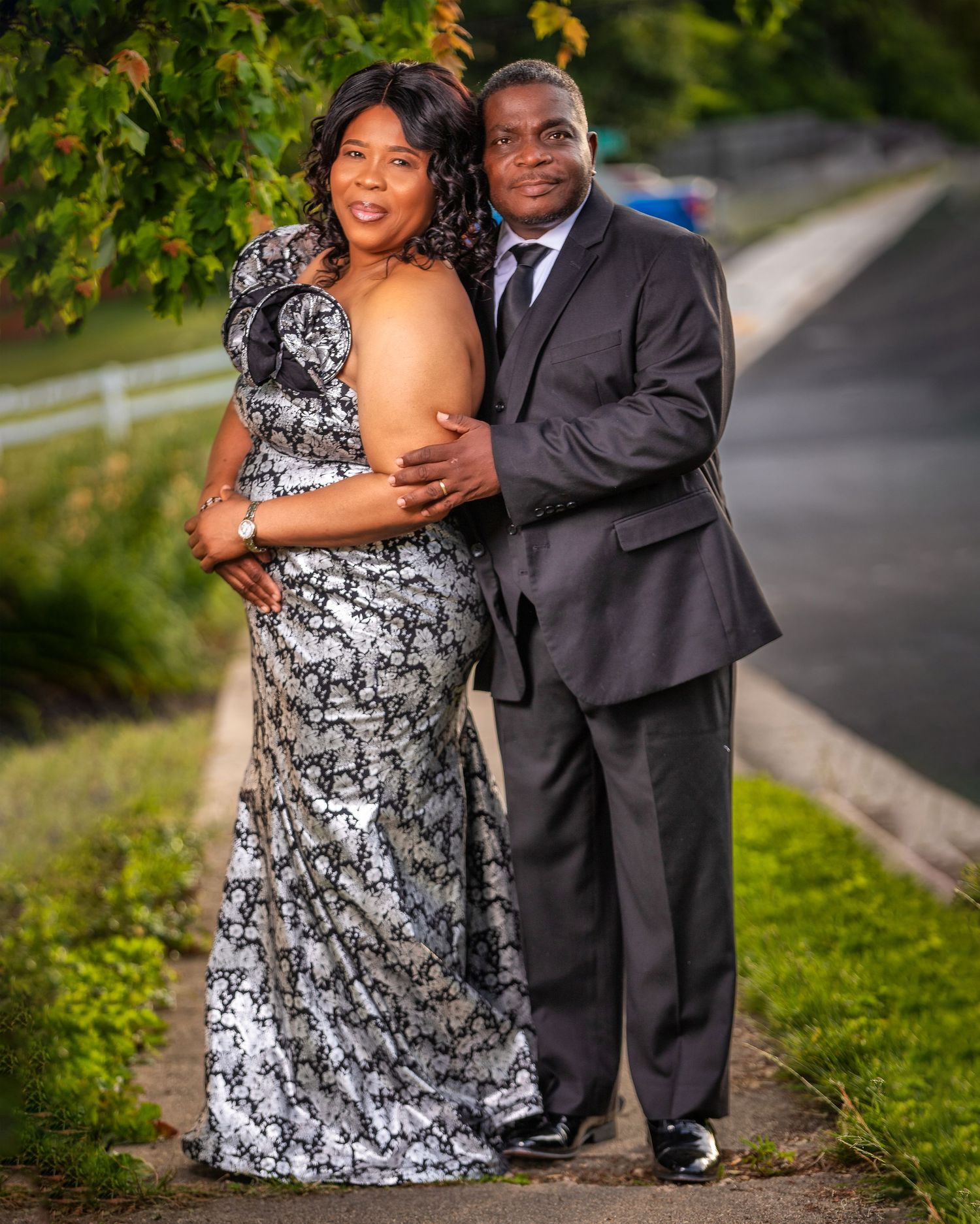 Romantic outdoor couple portraits in formal attire against a lush green background.