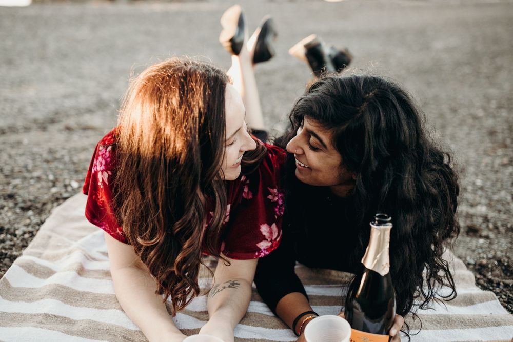 Couple lying on blanket sharing intimate moment outdoors.