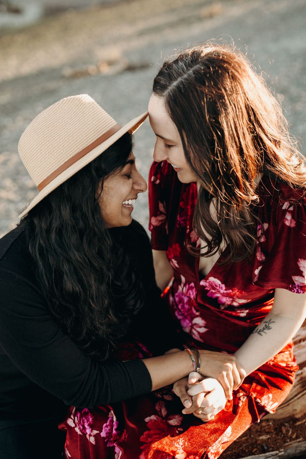 Couple in red dress and black outfit share joyful moment outdoors.