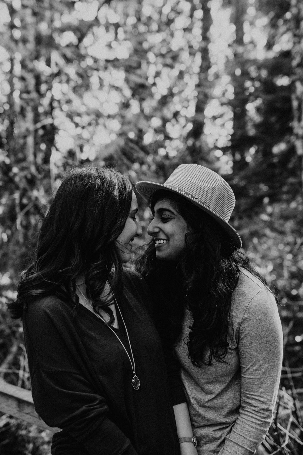 A couple shares an intimate moment in a lush forest setting.