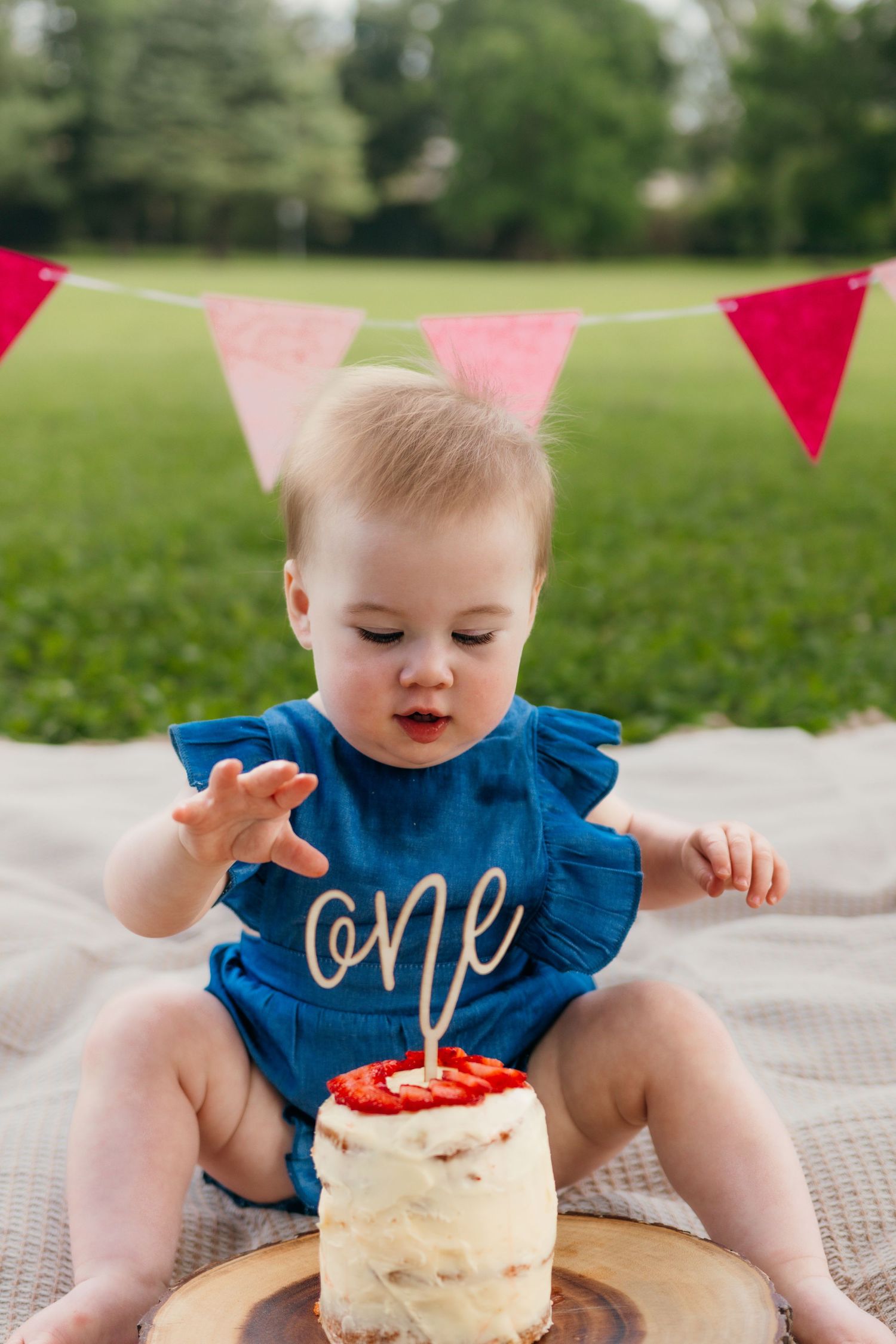 Baby Penelope smiling during her pink-themed cake smash session.