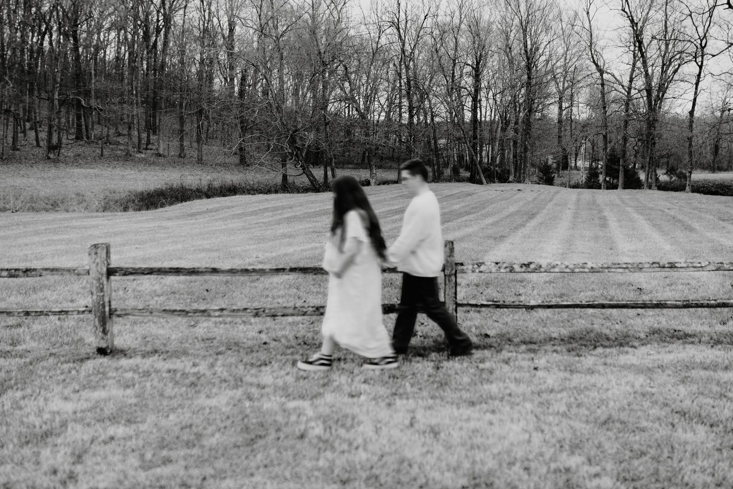 Black and white landscape photo with figures in a misty field.