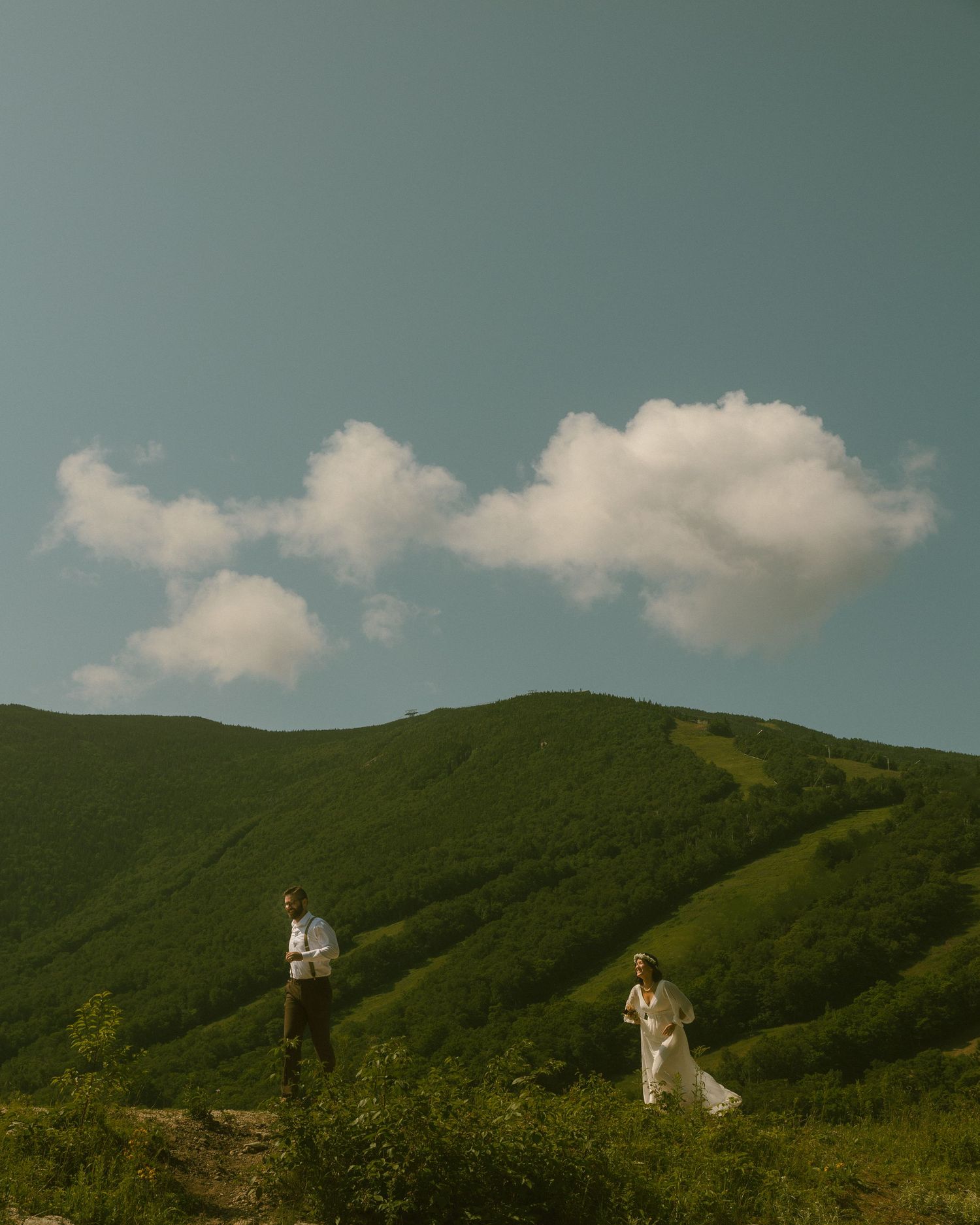 Rolling green mountains under a blue sky with white clouds.