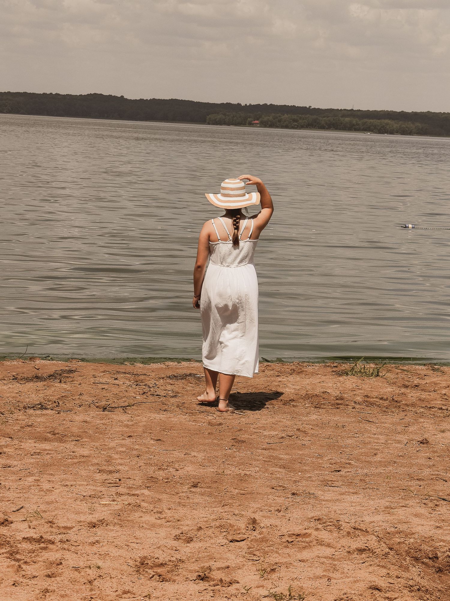 Photo of a mother and young son embracing each other in a park, while wearing white.  Blue Onion Photography.