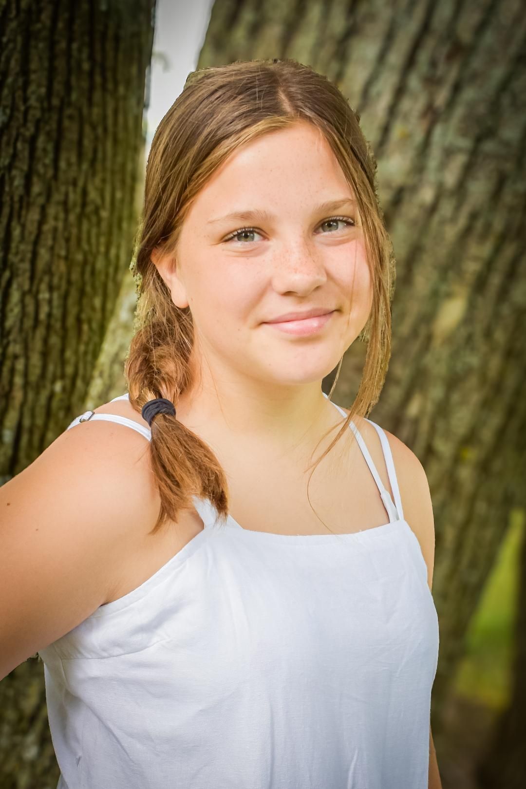 Photograph of a smiling girl in nature.  Blue Onion Photography.