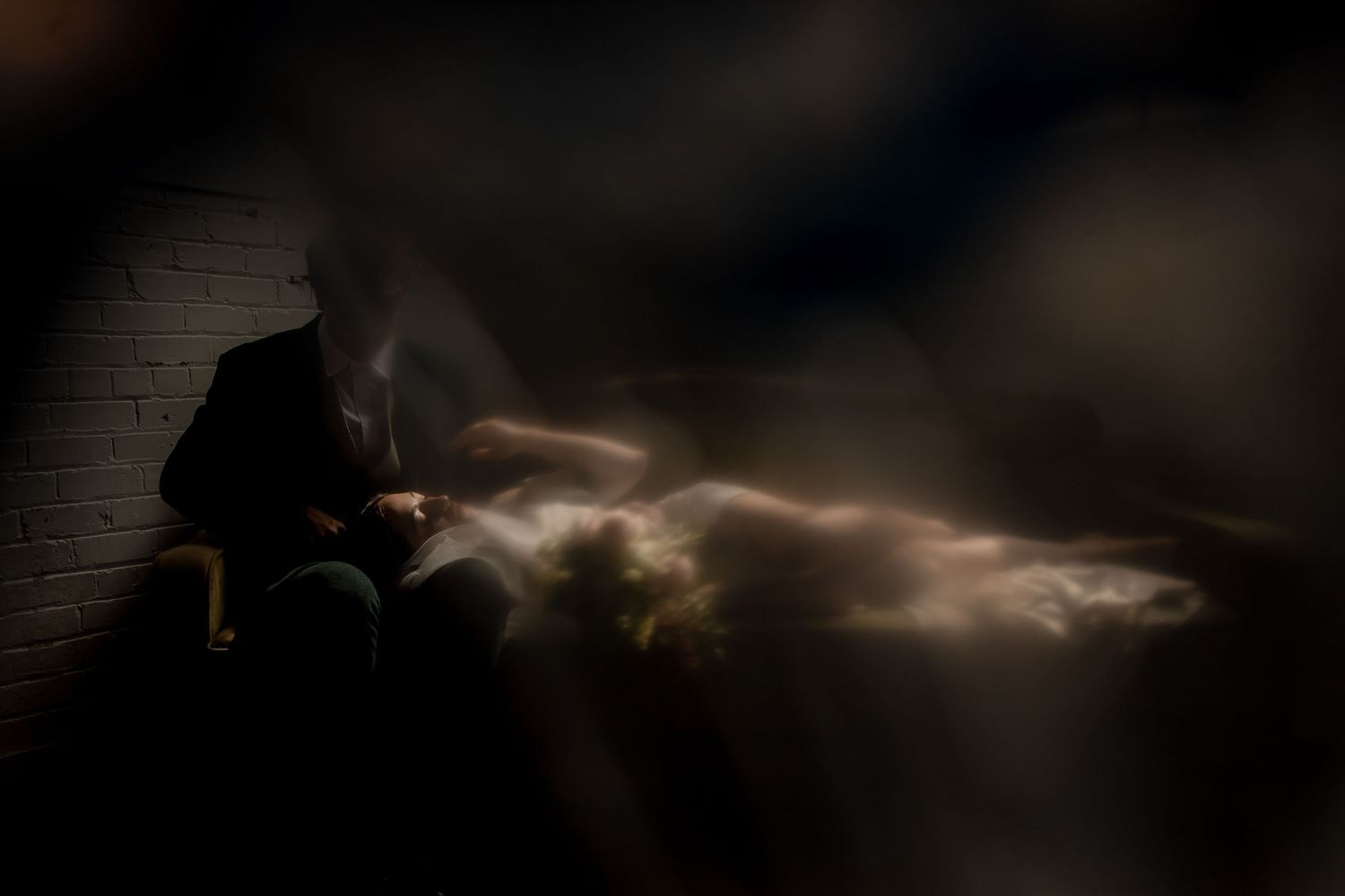 Dramatic silhouette photo with ethereal light beams in dark setting.