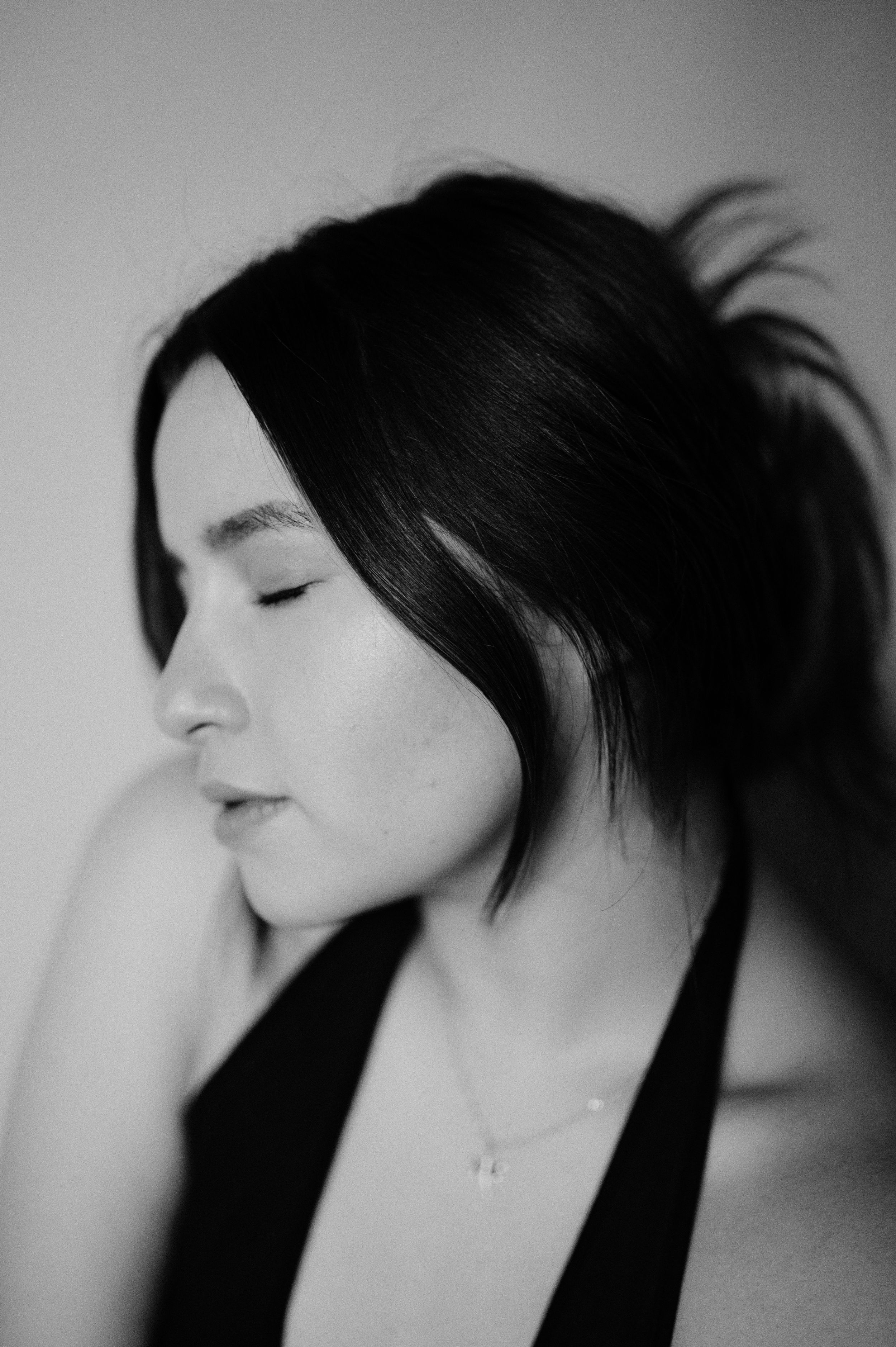 Artistic black and white profile portrait with soft lighting and serene expression.