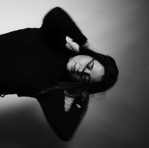Artistic black and white portrait with dramatic shadows and reflective surface.