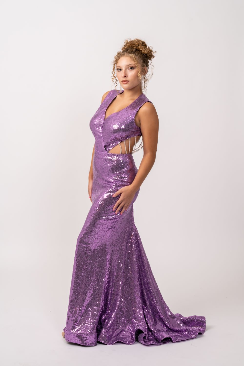 Floor-length purple sequin gown with cutout details and mermaid silhouette.