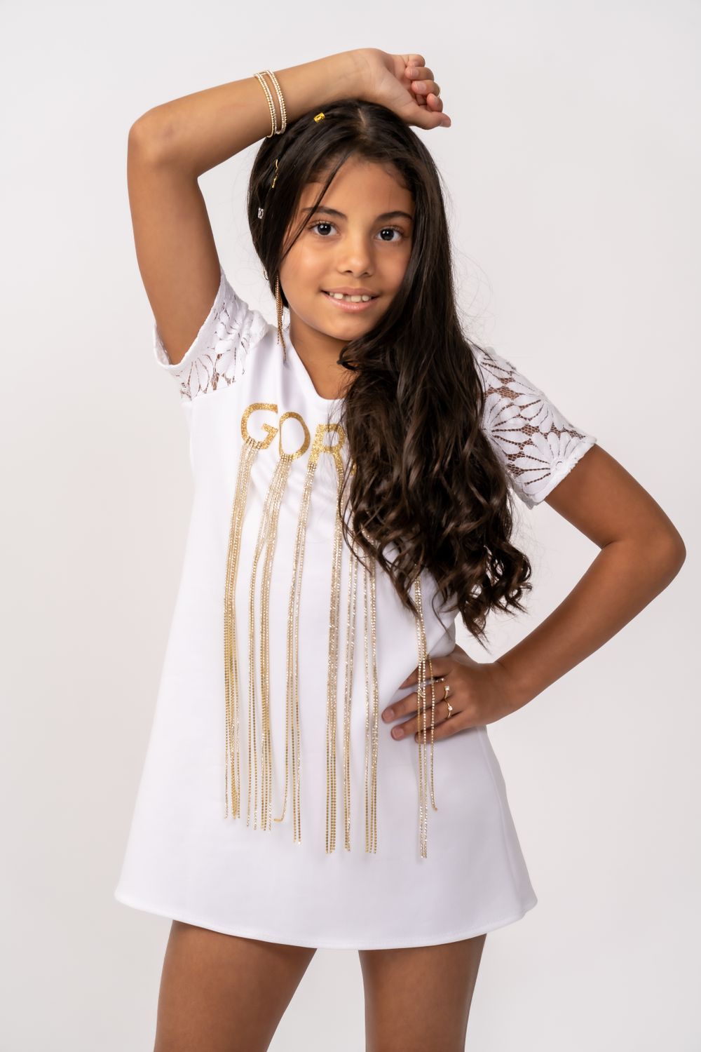 White mini dress with gold metallic fringe and lace details.
