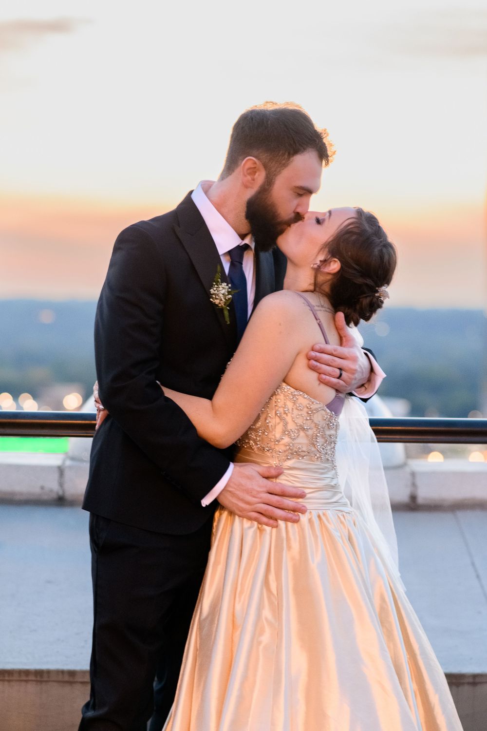 A romantic embrace captured during golden hour on a rooftop terrace.
