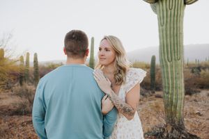 Intimate desert engagement photos captured among giant saguaro cacti in Arizona.