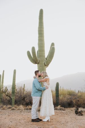 Desert engagement session featuring intimate poses against majestic saguaro cacti.