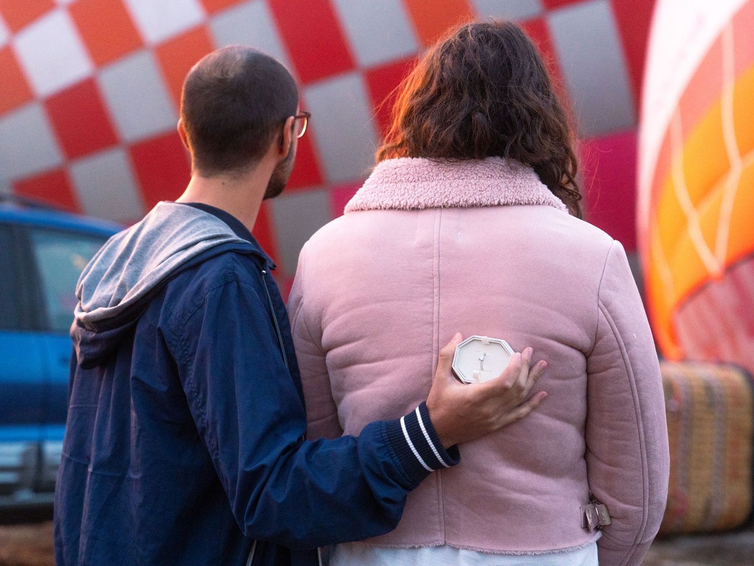 People walking together against a red and white checkered background in casual attire.