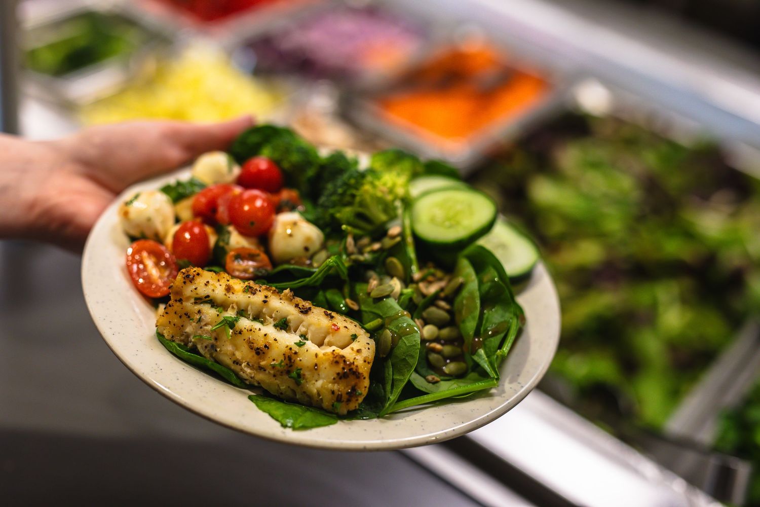 Fresh salad plate with grilled corn, cucumber slices, cherry tomatoes and mixed greens.