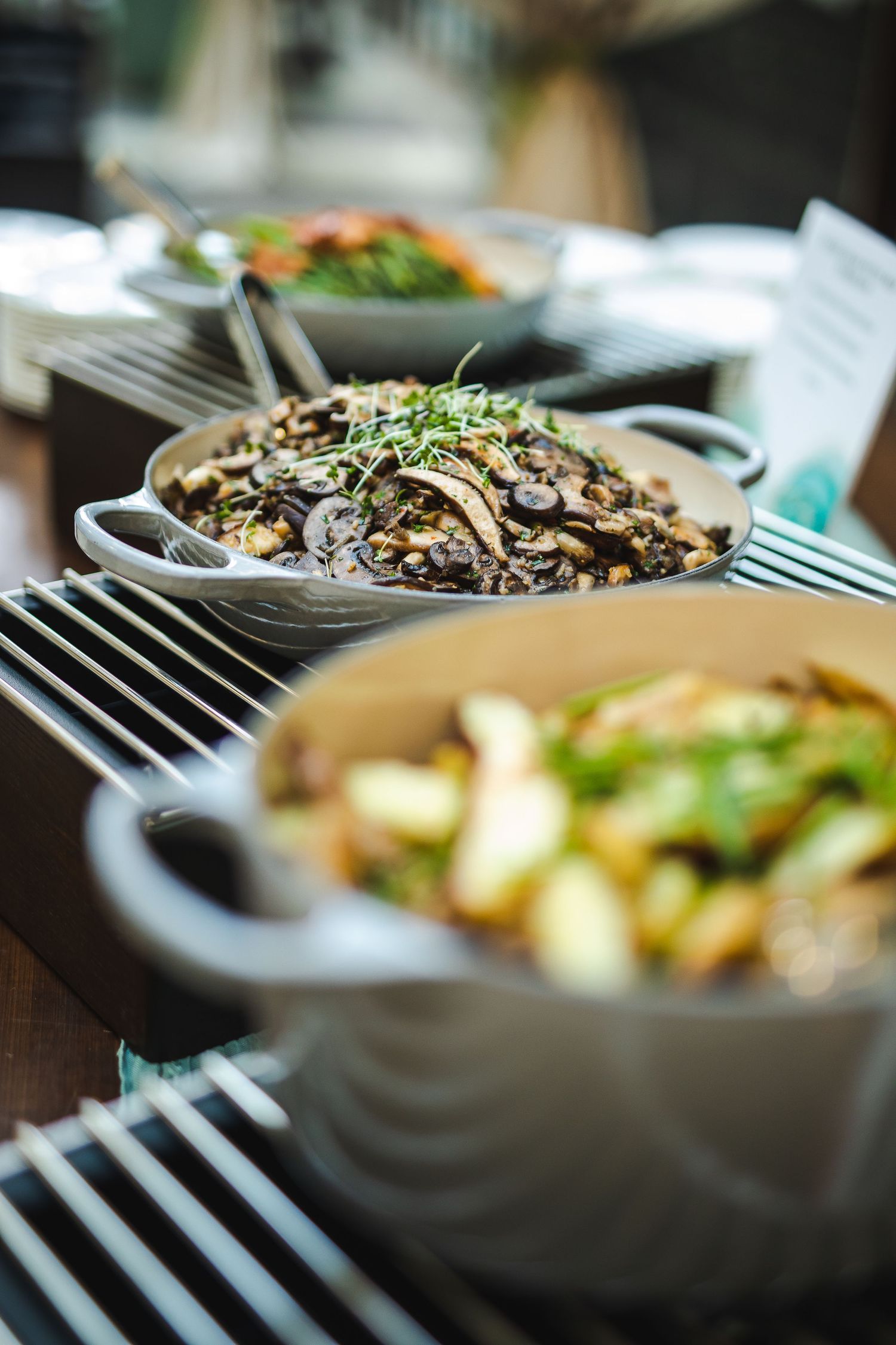 Gourmet mushroom and grain dish garnished with microgreens served in white ceramic bowls.