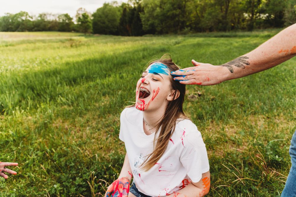 Paint play activity with colorful splashes in outdoor summer setting.