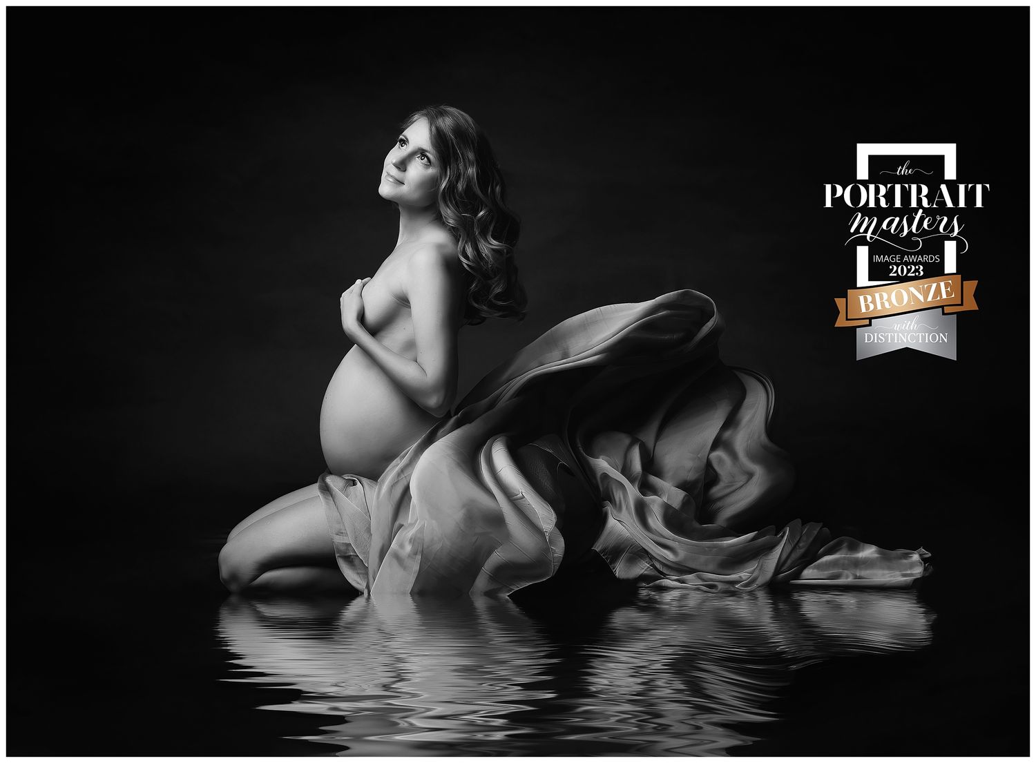 portrait of pregnant mom kneeling in water, draped in flowing silk. Maternity PHotographer Valerie Kay Photography