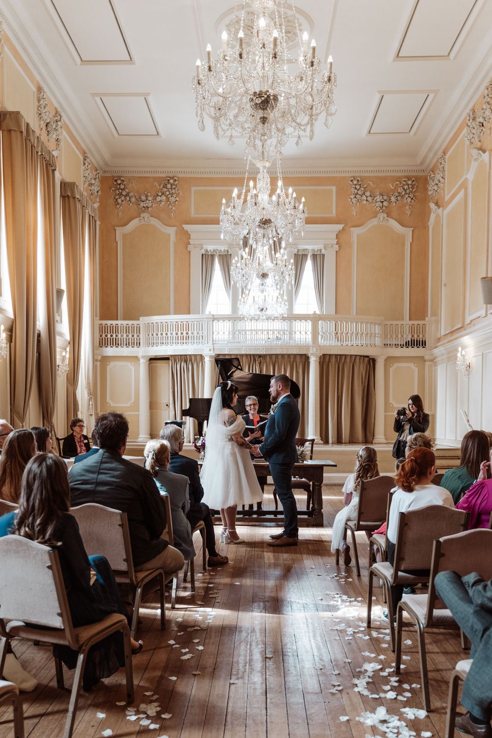 a bride and groom exchanging vows, holding hands.