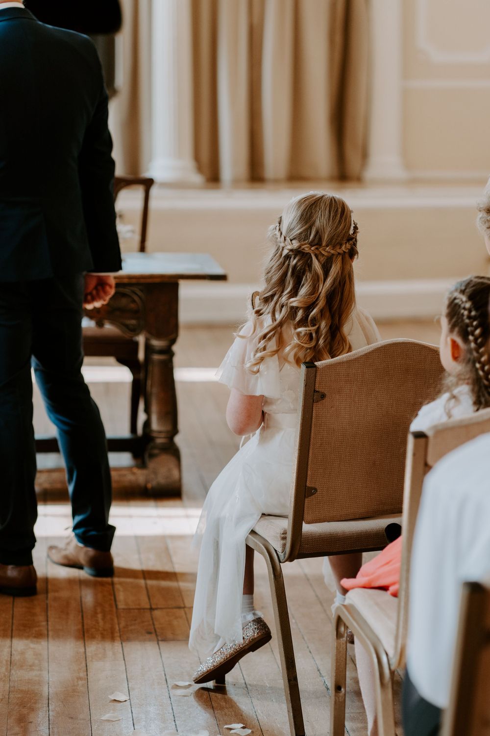 the back of a flower girl watching her parents get married.