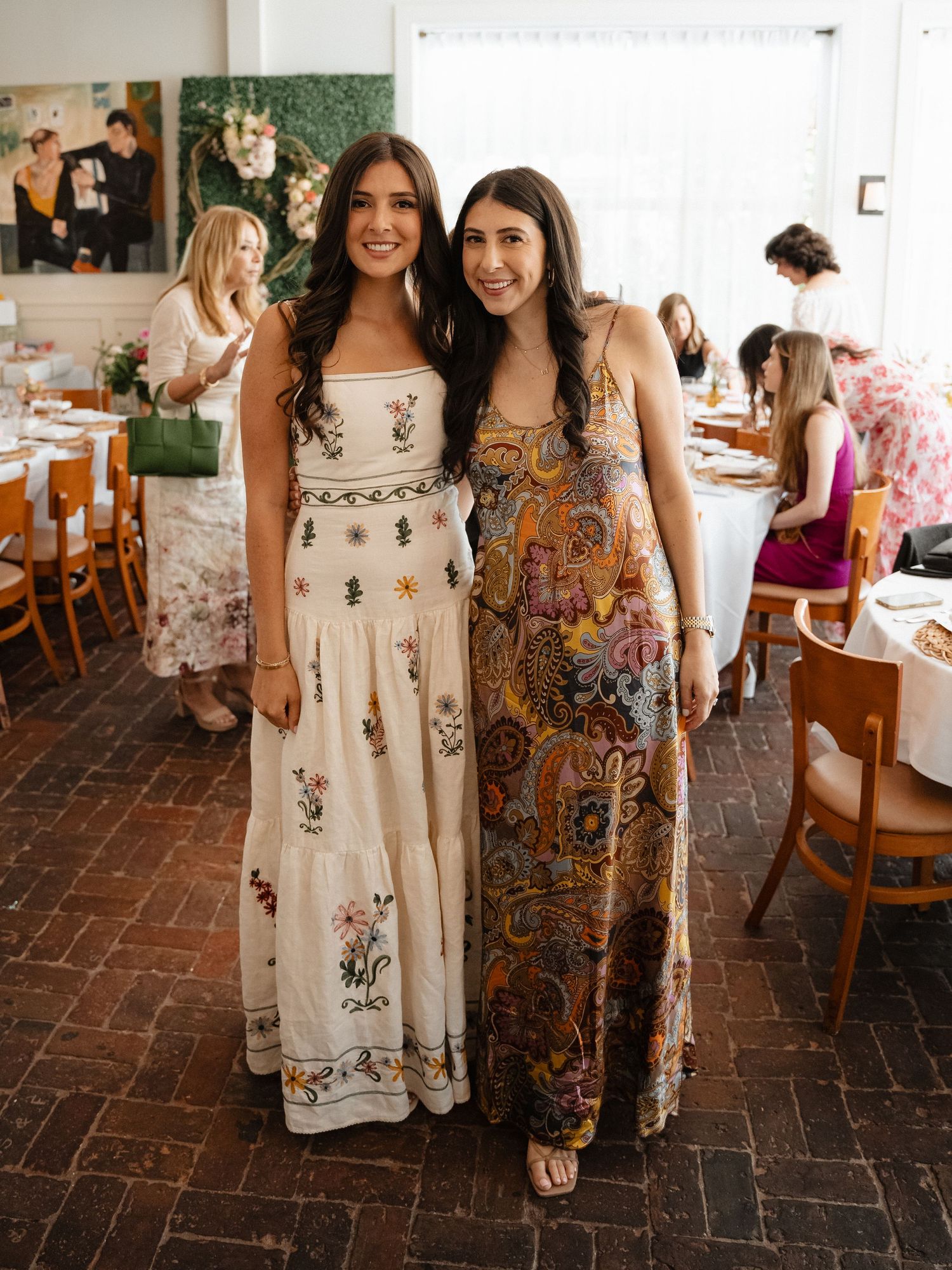 Ladies in floral and patterned dresses gathered at an indoor celebration.