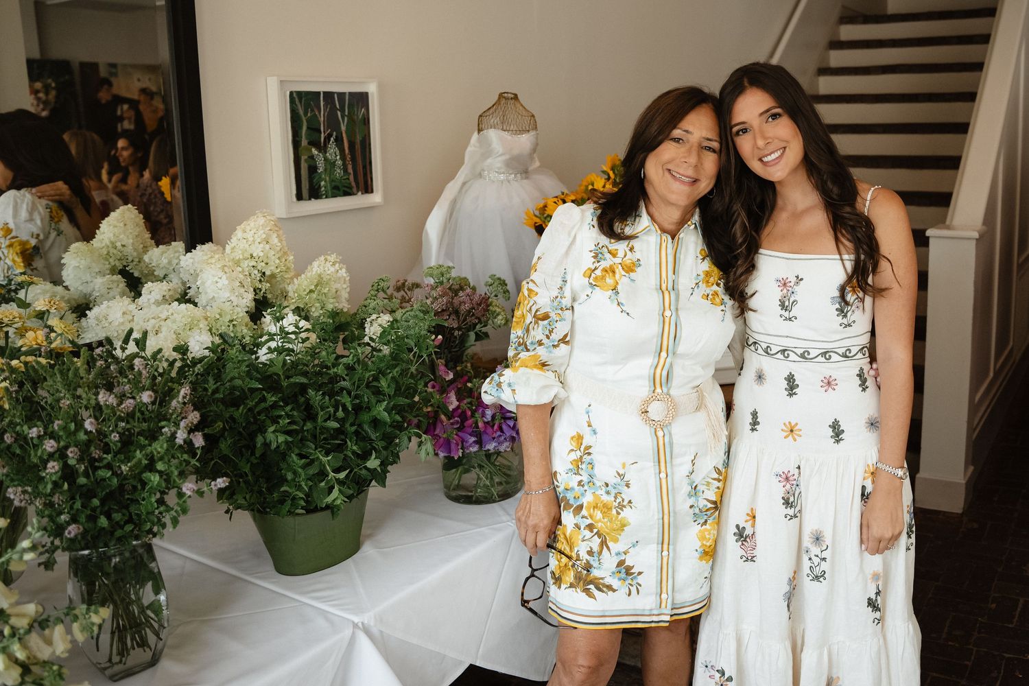 Celebration gathering with women in white and floral summer dresses.