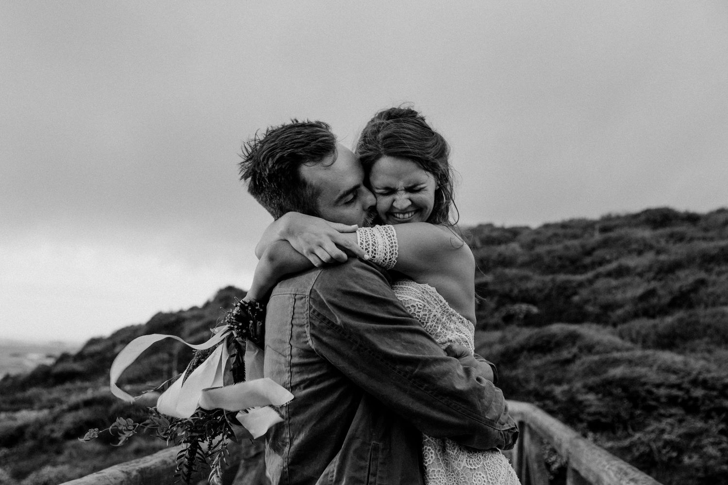 Black and white photograph of an embrace on a misty hilltop.