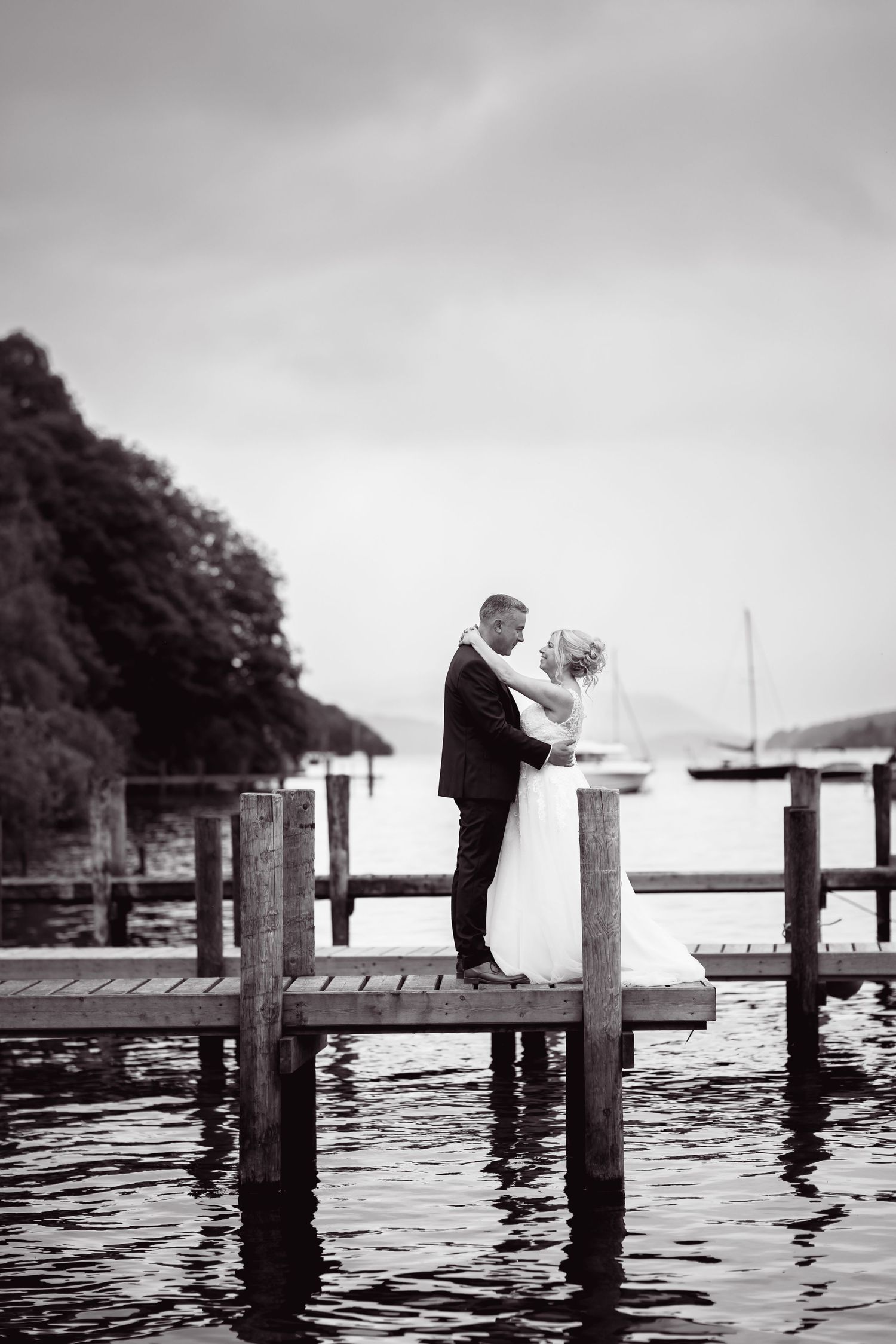Romantic black and white photo on a wooden dock over tranquil water.