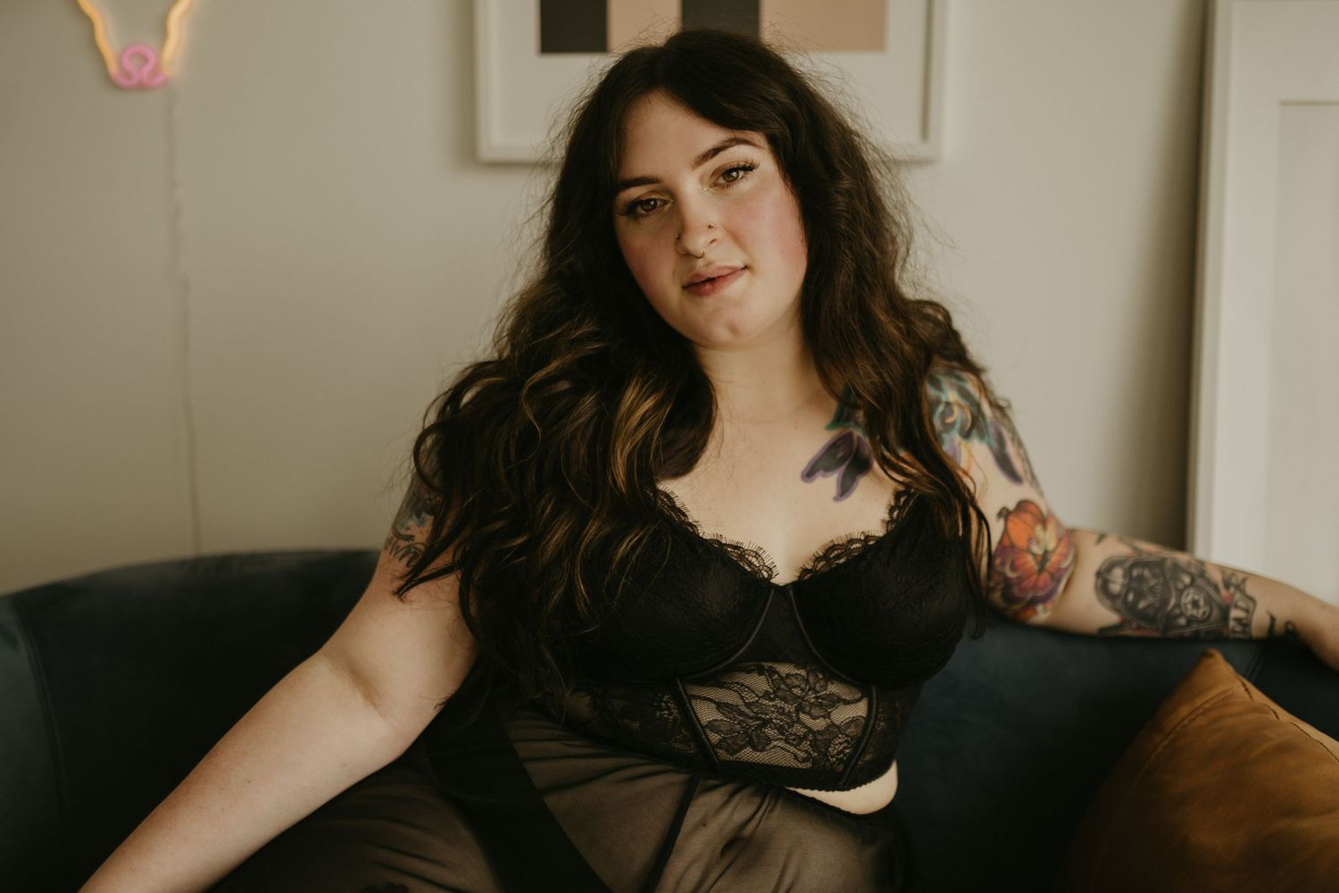 Pretty tattooed girl with nose ring smiling at camera