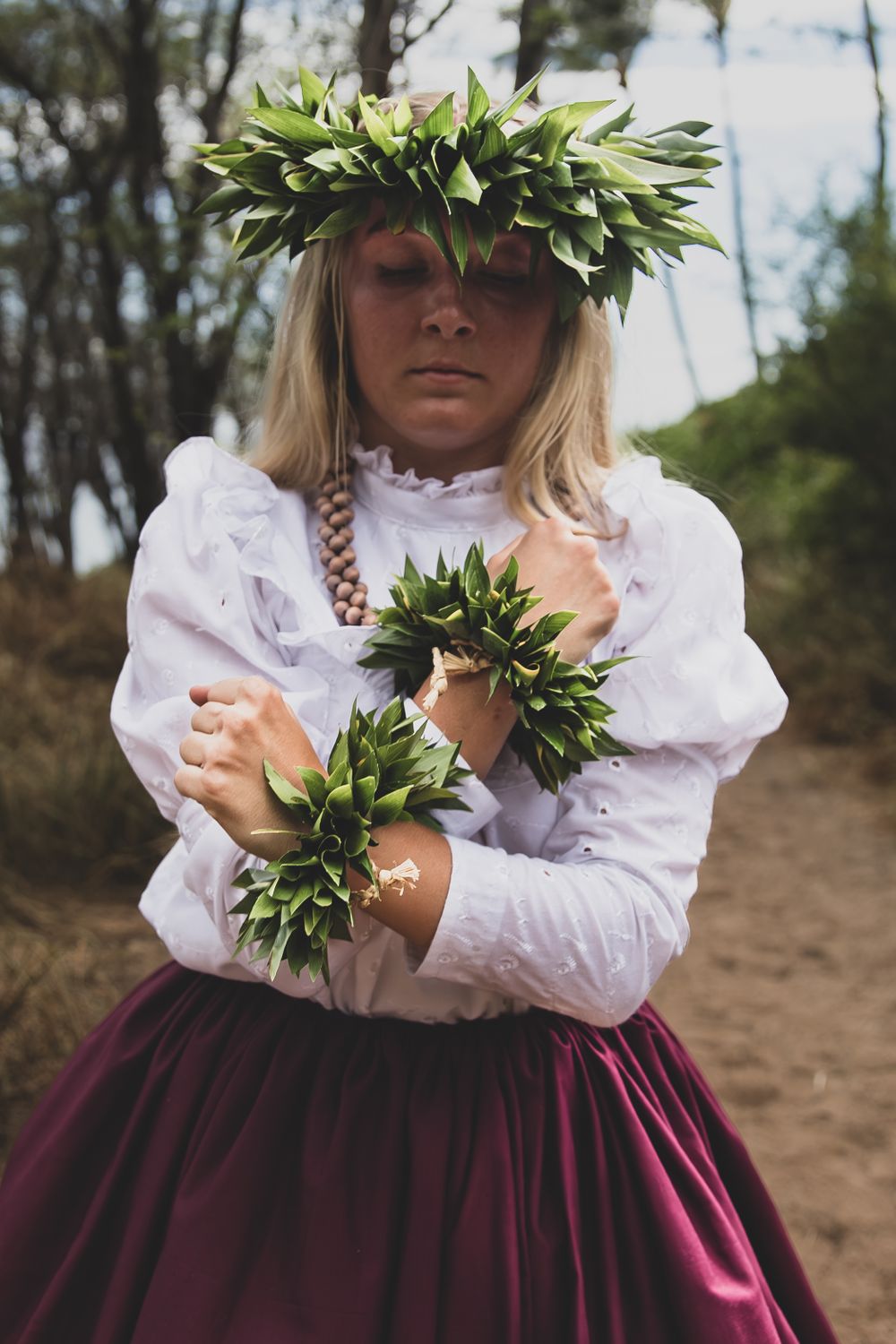 Artistic portrait of hula dancer with leaf crown and traditional costume in natural lighting.