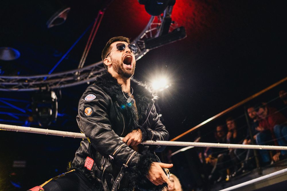 Wrestling performance with dramatic red lighting and stage effects.