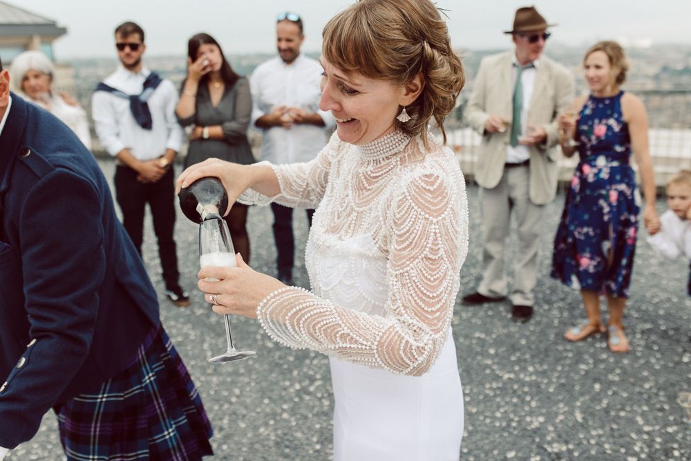 Guests dancing and celebrating at outdoor wedding reception with city views.