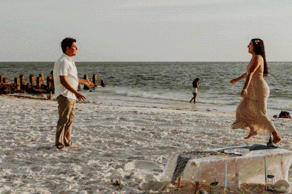 Couple on beach spinning around in Florida
