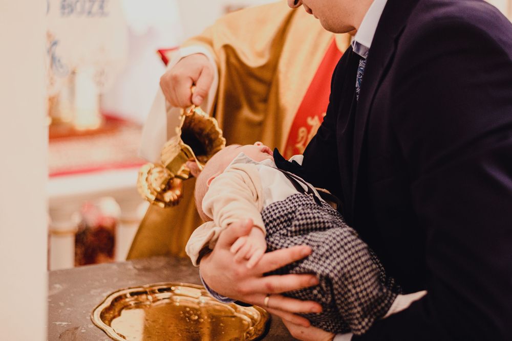 Close-up of hands holding and caring for an infant.