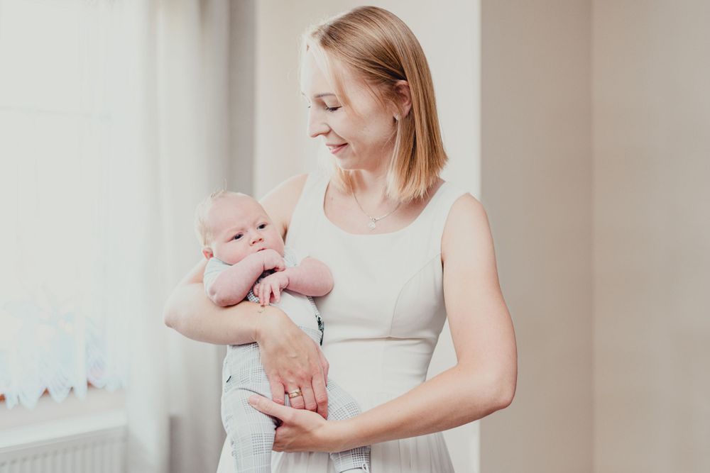 Mother and baby bonding moment captured in soft natural lighting.