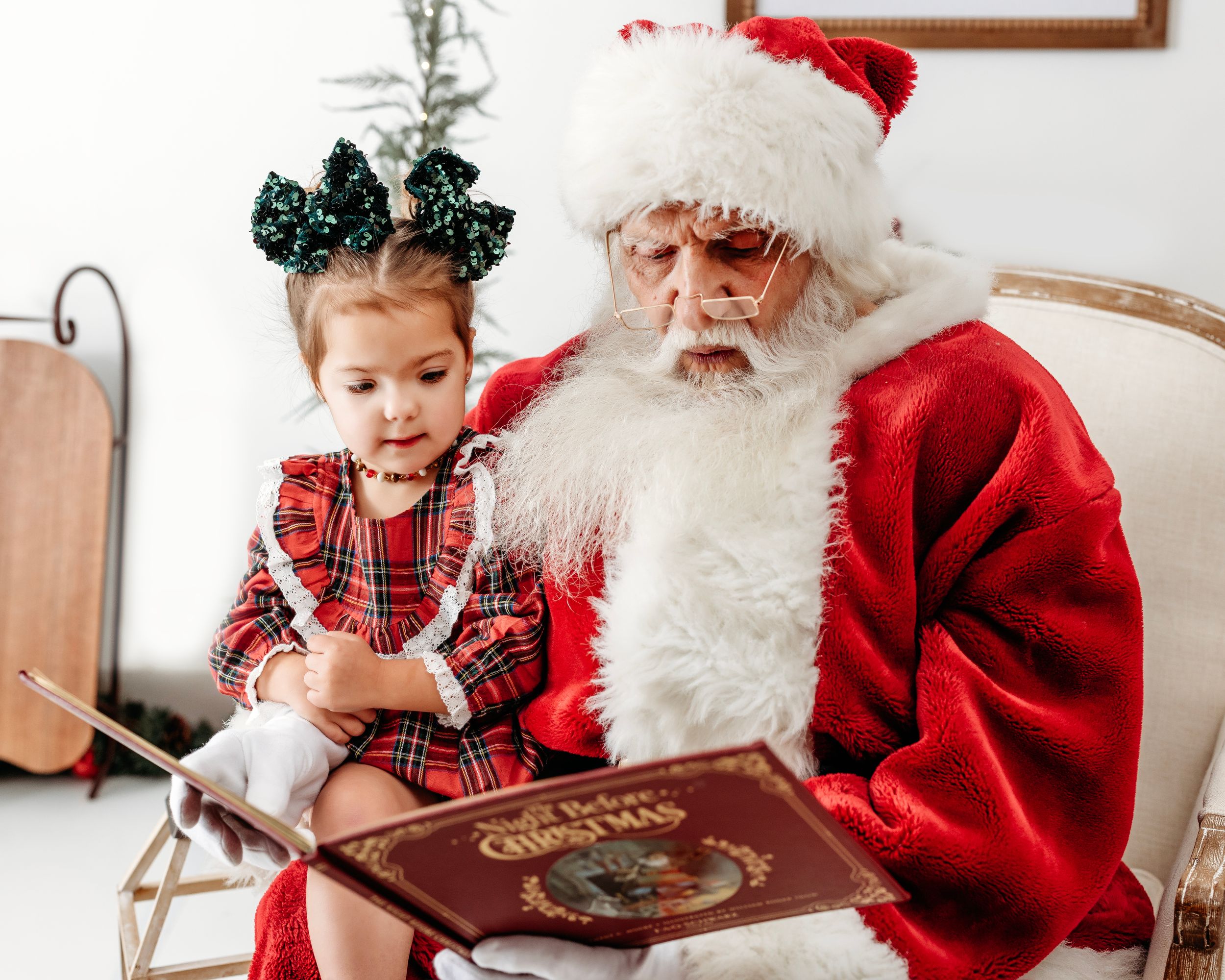 Christmas photo session featuring a decorated book and festive holiday decor. Santa photographer