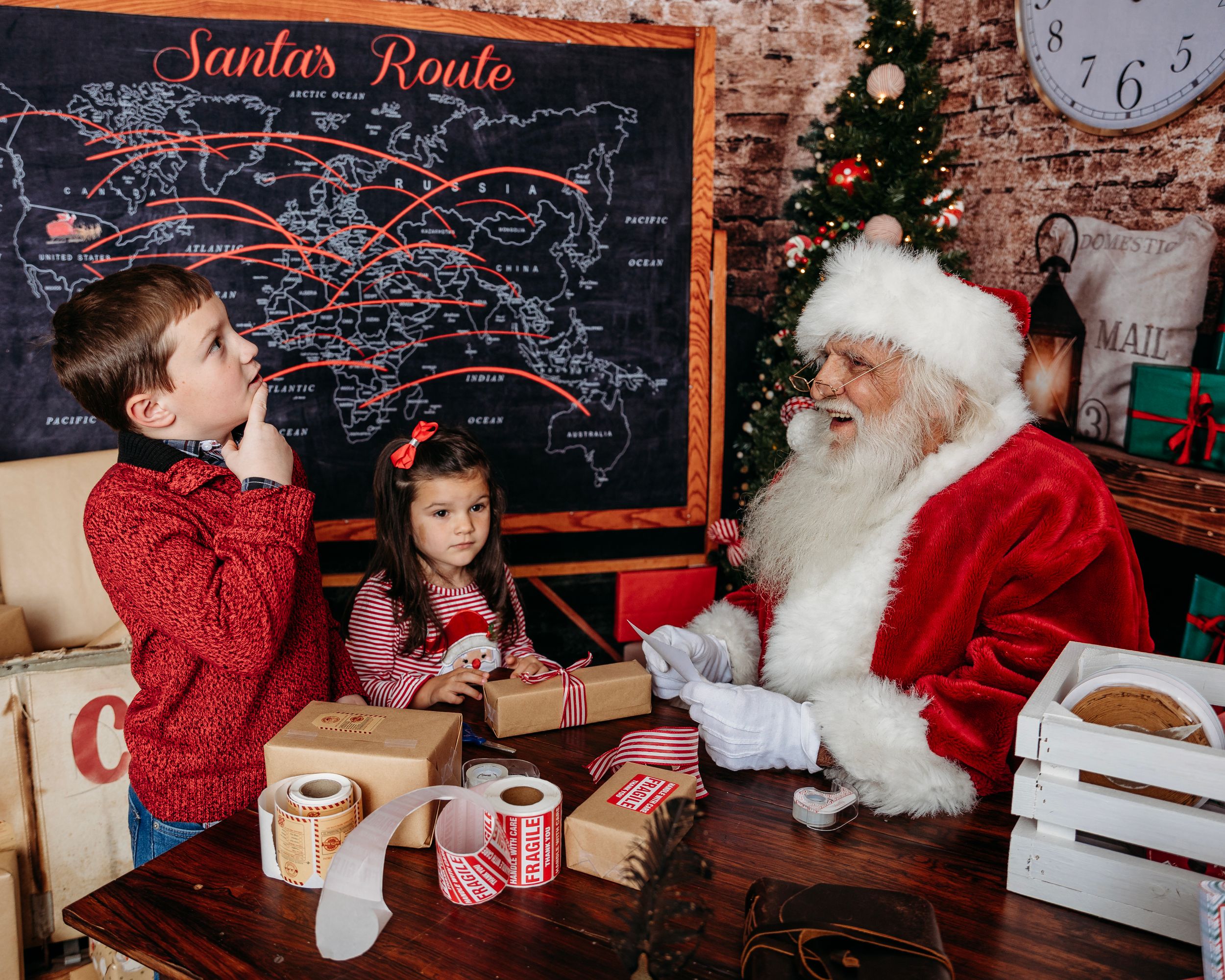 Christmas photo setup with Santa's Route chalkboard and rustic holiday decorations. Santa photographer