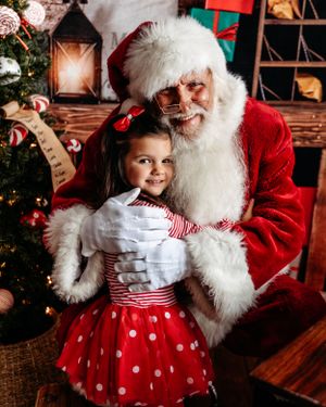 Christmas photo session with red and white polka dot dress and holiday decorations. Santa photographer