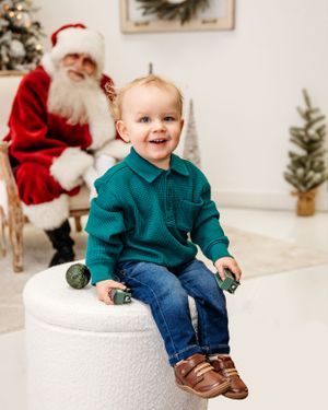 Holiday photo session backdrop featuring a white platform and decorated Christmas trees. Santa photographer
