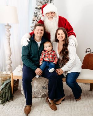 Christmas family photo session with white and green holiday decor. Santa photographer