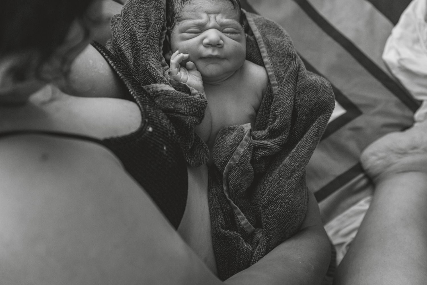 Person in dark clothing resting in water during labour. Photographer. Hull. East Yorkshire. Photography