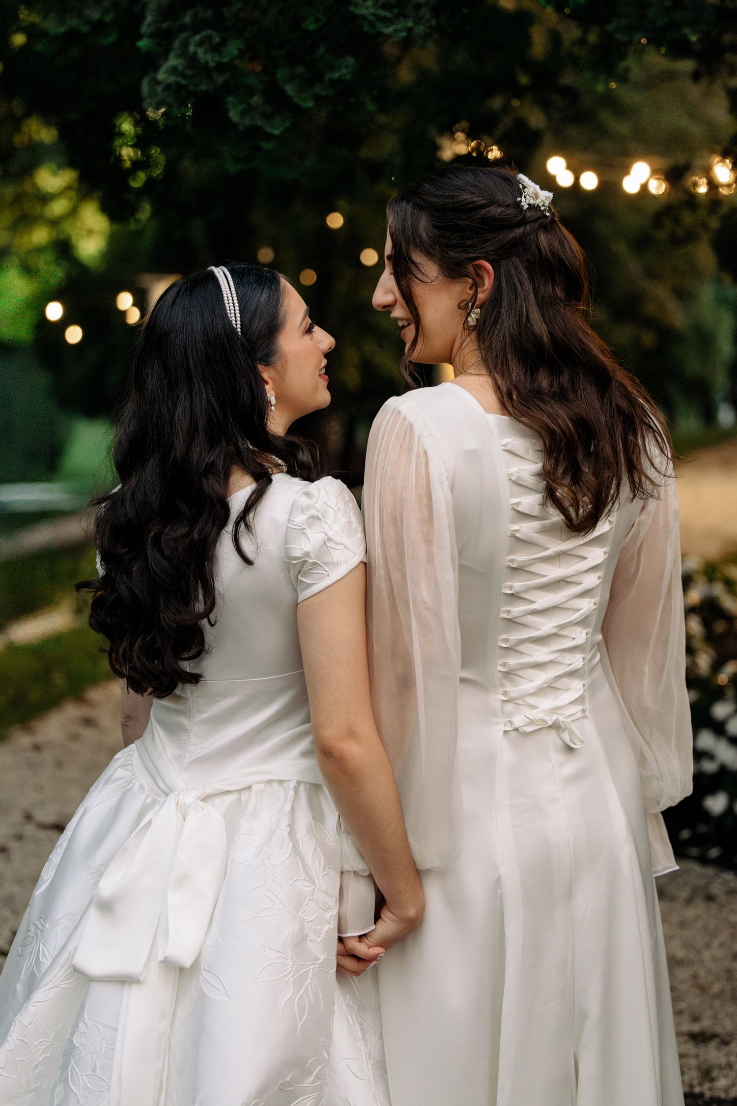 Bride in flowing white dress poses dramatically in golden-lit elevator.