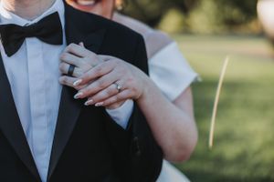 Wedding couple clinking champagne glasses during formal reception toast.