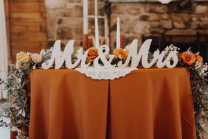 Rustic wooden wedding venue decorated with elegant signage and lighting.