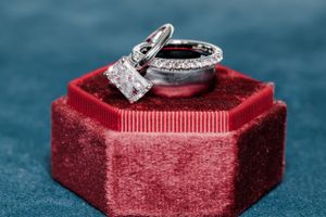 Diamond wedding rings displayed on red velvet ring box.
