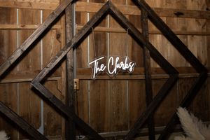 Rustic wooden wall decor featuring geometric black frames and cursive text sign.