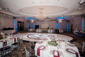Elegant ballroom reception setup with round tables and crystal chandelier.